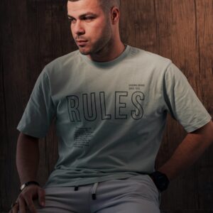 Portrait of a man in casual streetwear fashion against a wooden background.