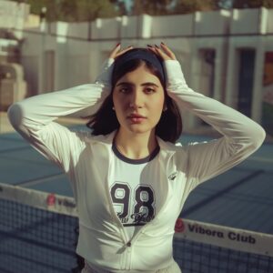 A young woman poses confidently on a tennis court in Baghdad, Iraq.